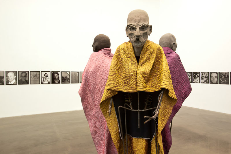 Томас Шютте. Трое способных мужчин. 2005. Инсталляция. Музей Стеделейк, Амстердам. На заднем плане: Михаэль Шмидт. Е-ДИН-СТВО 1991–1994. Фрагмент фотоинсталляции. Собрание Дакиса Иоанну. Вид экспозиции выставки «Остальгия» (куратор Массимилиано Джони) в Новом музее современного искусства, Нью-Йорк, 2011. Источник: www.sugarbarons.com